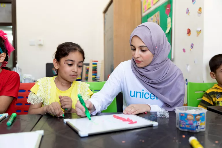 On 31 August 2022, UNICEF Goodwill Ambassador Muzoon Almellehan sits with Ahla, 8, during an Arabic learning support class at a UNICEF-supported Makani centre in East Amman, Jordan.