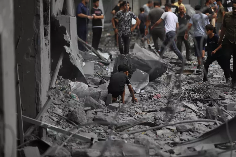 Children amidst the wreckage of homes destroyed by airstrikes in Al Shati Refugee Camp in the Gaza Strip.