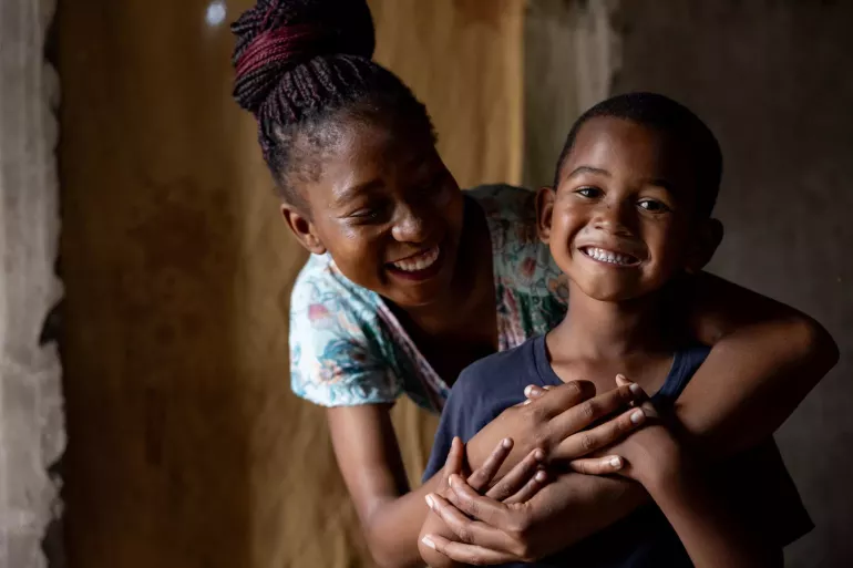 A smiling mom poses with her child in Mozambique.