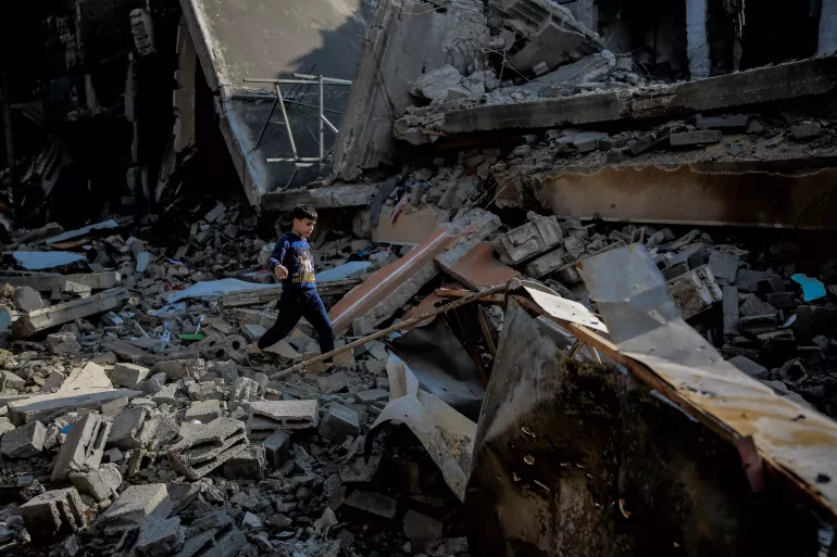 Mohammed, 9-year-old, walks over the rubble of his destroyed home at Omar Al-Mukhtar Street in Gaza City.