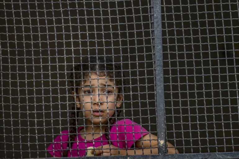 a girl behind a fence