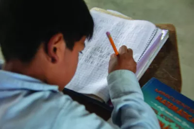 Ni&ntilde;o escribiendo en su cuaderno