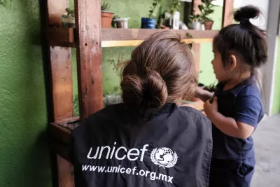 Personal de UNICEF con una ni&ntilde;a migrante centroamericana