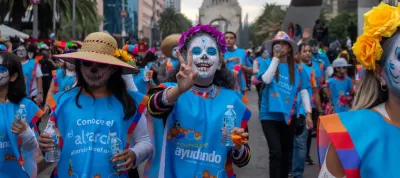 Grupo de j&oacute;venes con maquillaje de catrina y camisetas de UNICEF participan en un desfile de D&iacute;a de Muertos.