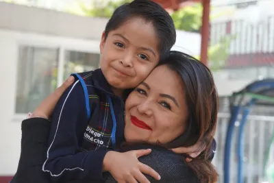 Madre e hijo abrazados y sonriendo, ilustrando el v&iacute;nculo afectivo en la crianza positiva