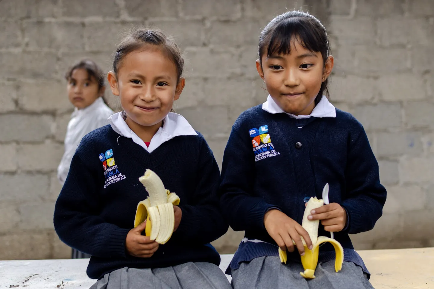 Dos ni&ntilde;as comiendo fruta en la escuela