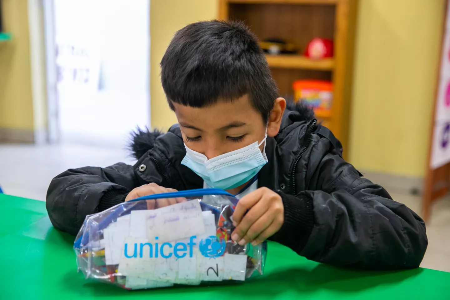 Ni&ntilde;o con una lapicera que dice UNICEF