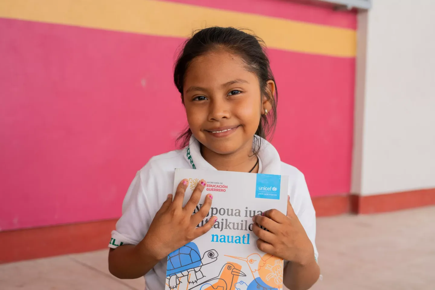 Una ni&ntilde;a sosteniendo su ibro en n&aacute;huatl