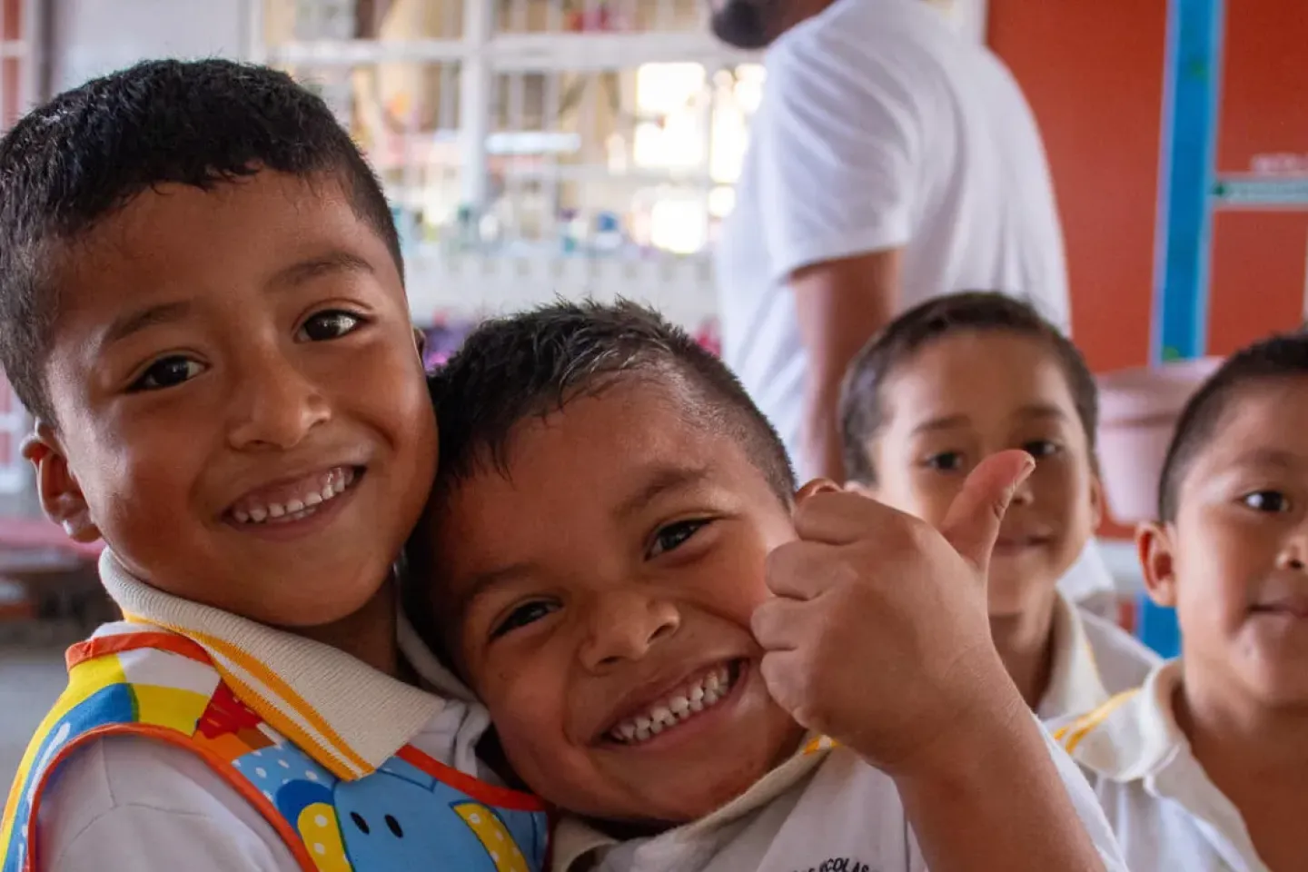 Ni&ntilde;os en edad escolar sonr&iacute;en y juegan juntos en el patio de su escuela.