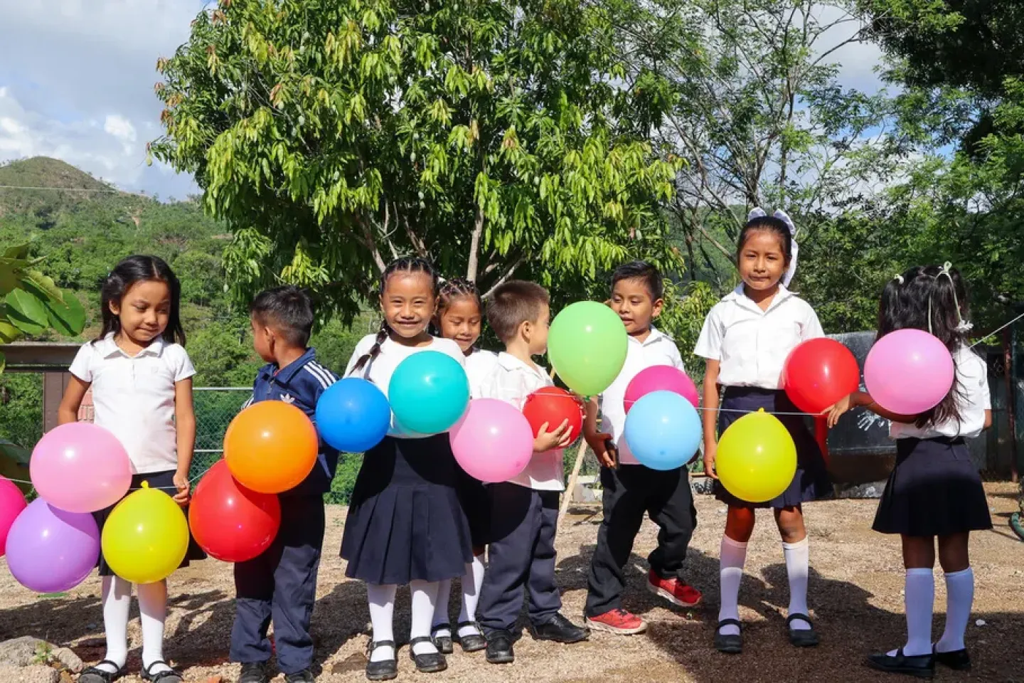 un grupo de ni&ntilde;as y ni&ntilde;os peque&ntilde;os en Guerrero sonriendo y sosteniendo unos globos de colores