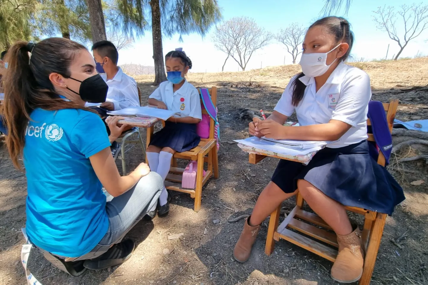Una colaboradora de UNICEF platica con una ni&ntilde;a en una escuela de Guerrero