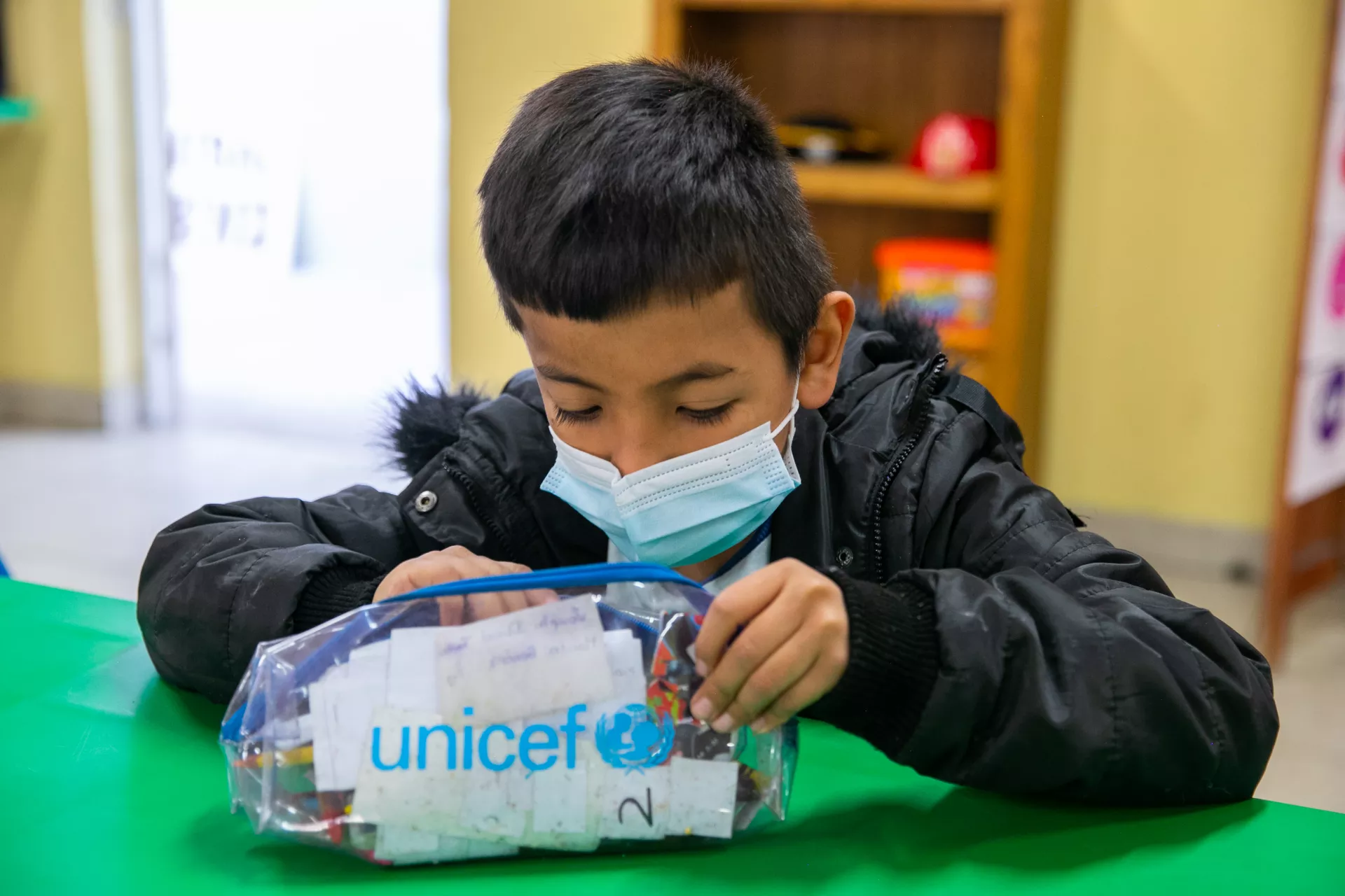 Ni&ntilde;o con una lapicera que dice UNICEF