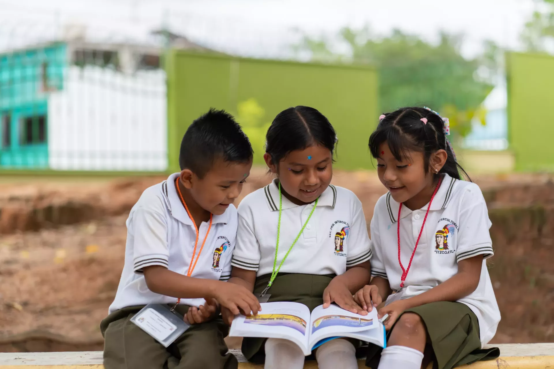 Dos ni&ntilde;as y un ni&ntilde;o leyendo un libro en Guerrero