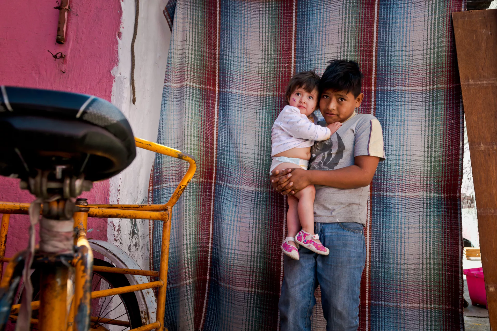 Un ni&ntilde;o cargando a su hermana peque&ntilde;a