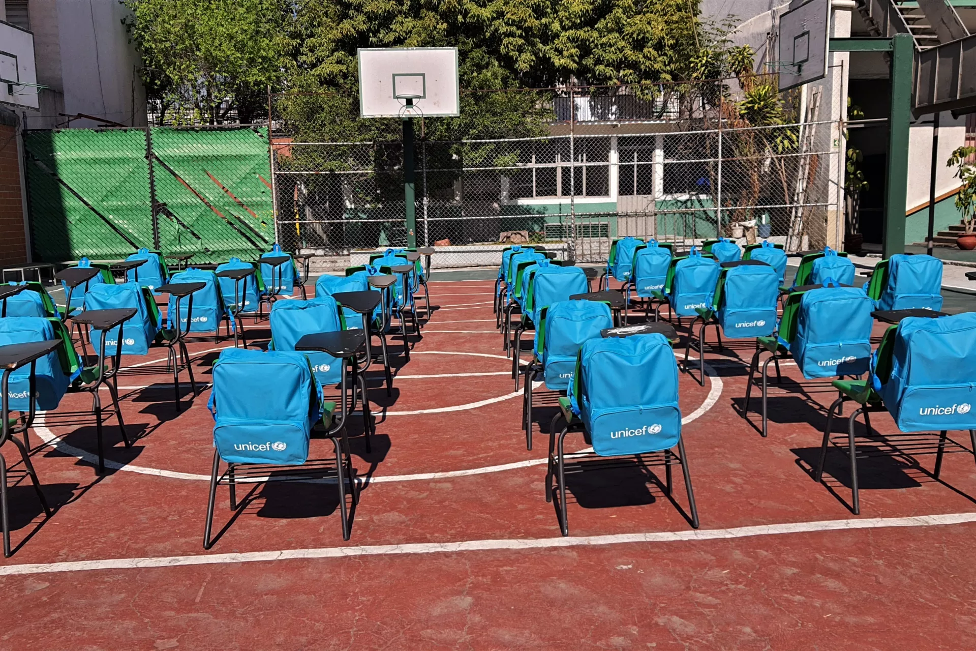 Mochilas y pupitres vac&iacute;os en una escuela
