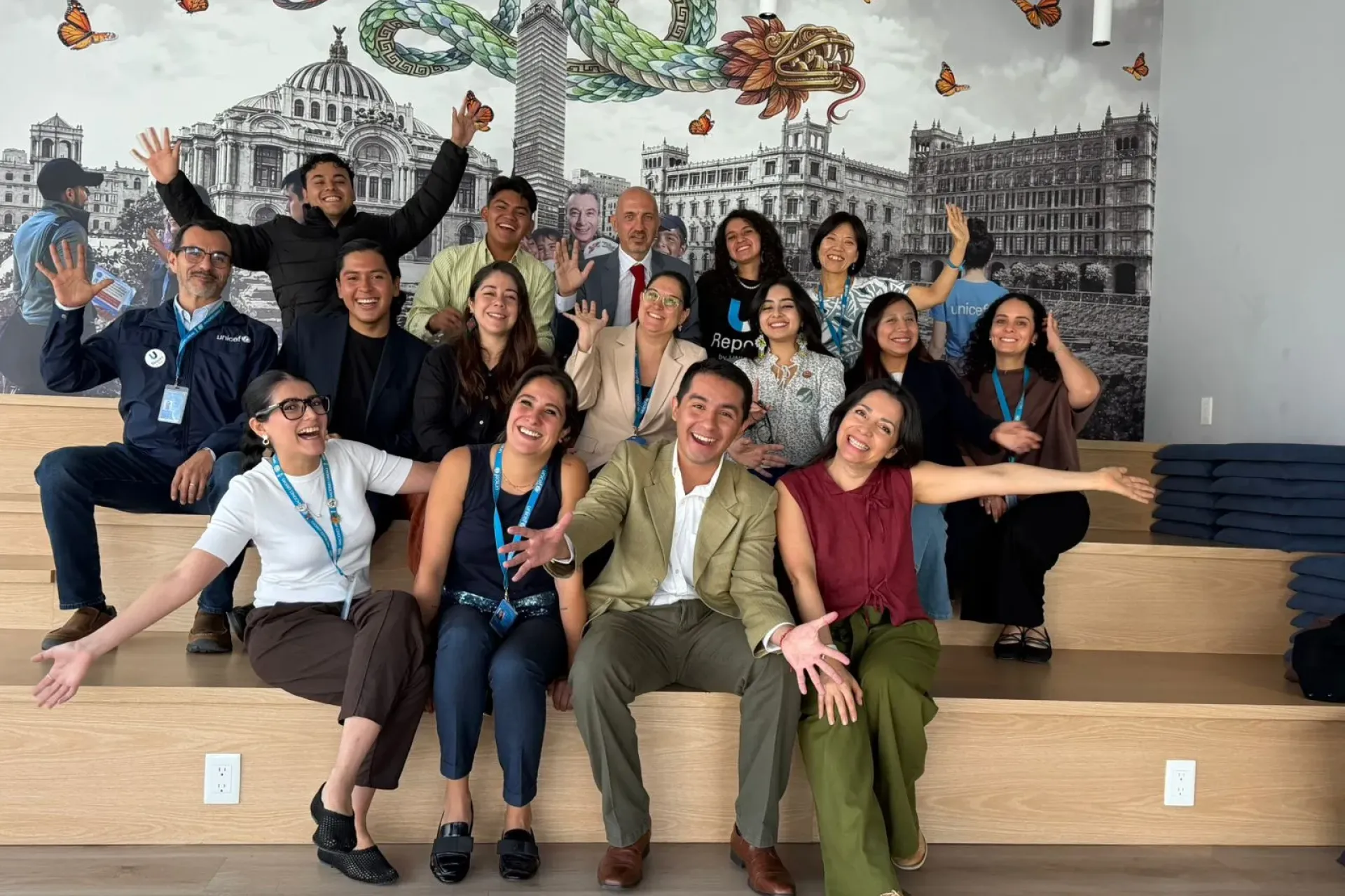 J&oacute;venes y personal de UNICEF posan sonrientes y con los brazos abiertos durante un encuentro sobre justicia clim&aacute;tica