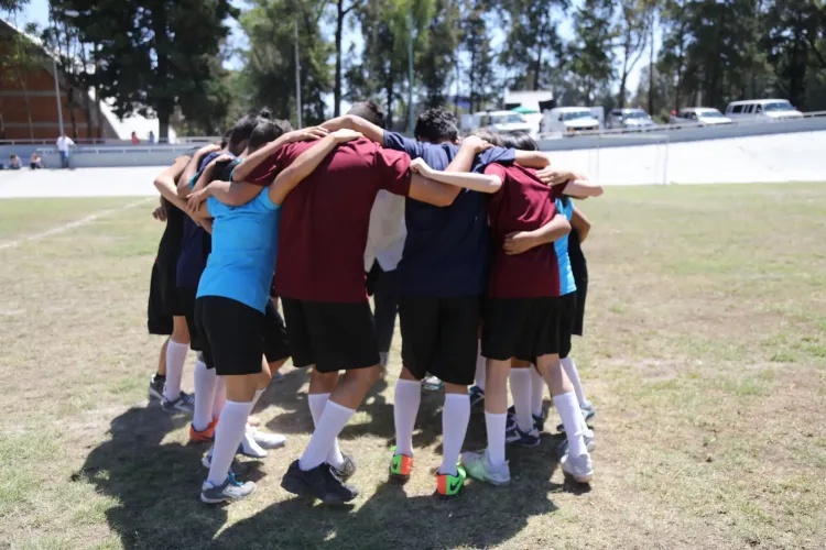 un equipo de ni&ntilde;as y ni&ntilde;os antes de iniciar un partido de futbol