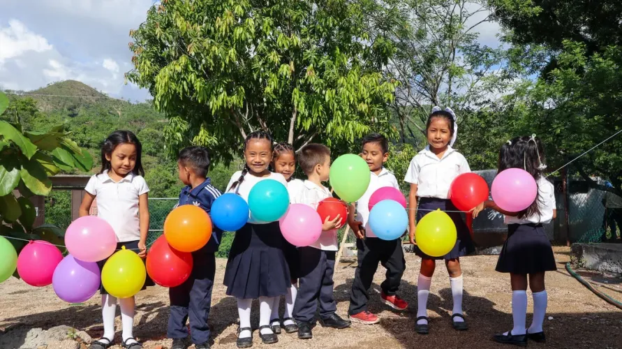 un grupo de ni&ntilde;as y ni&ntilde;os peque&ntilde;os en Guerrero sonriendo y sosteniendo unos globos de colores