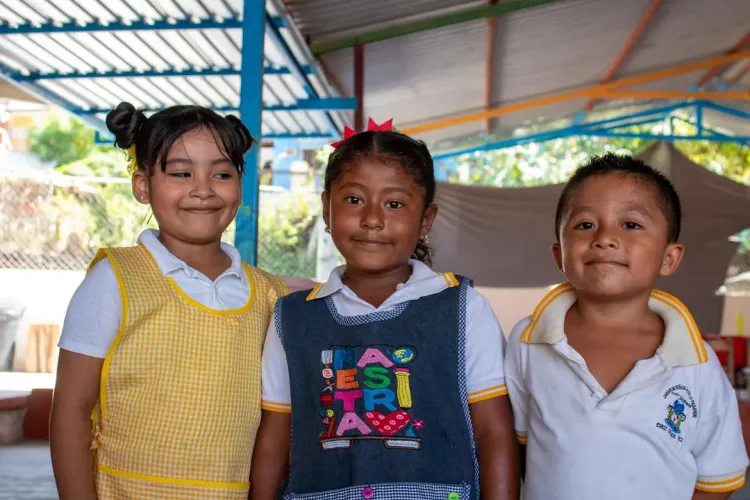 Dos ni&ntilde;as y un ni&ntilde;o peque&ntilde;os sonriendo a la c&aacute;mara. En el estado de Guerrero