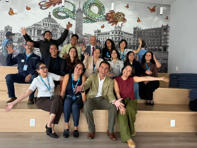 J&oacute;venes y personal de UNICEF posan sonrientes y con los brazos abiertos durante un encuentro sobre justicia clim&aacute;tica