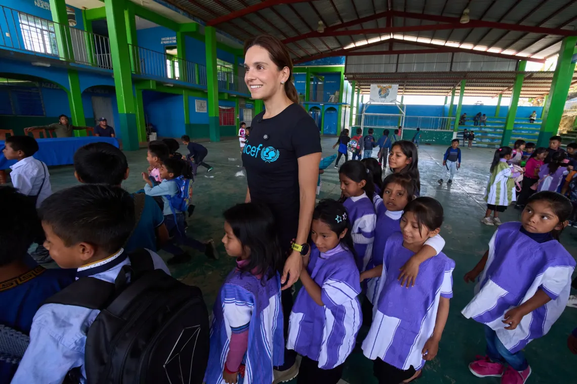 Tania Rinc&oacute;n en una escuela en Chiapas, tomando de la mano a una ni&ntilde;a y con otras ni&ntilde;as alrededor