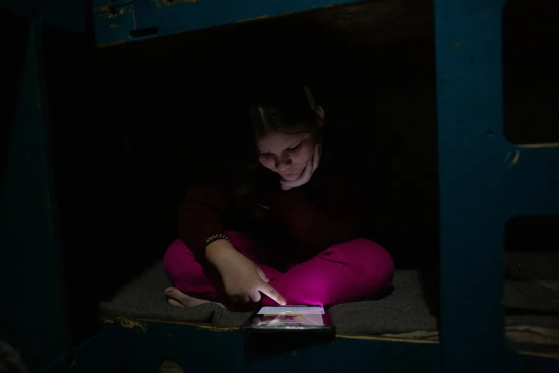 un ni&ntilde;a mirando un tel&eacute;fono m&oacute;vil