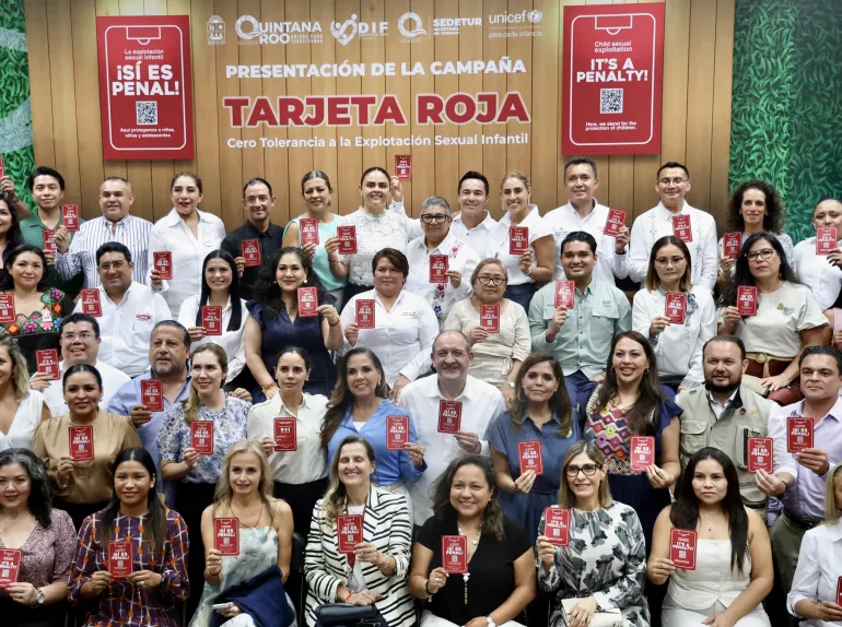 Participantes del lanzamiento de la campa&ntilde;a Tarjeta Roja sostienen las tarjetas rojas frente al logotipo de la campa&ntilde;a y las instituciones aliadas en el Planetario Ka'Yok' de Canc&uacute;n