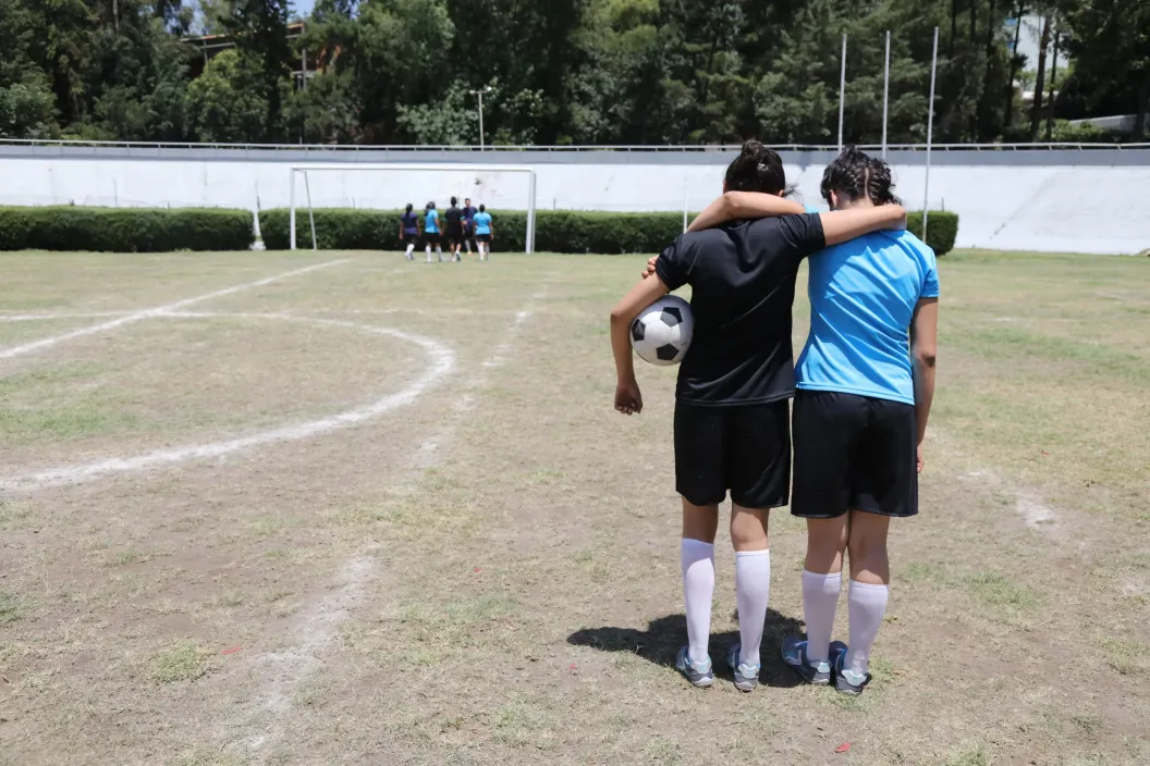 dos adolescentes en una cancha de futbol