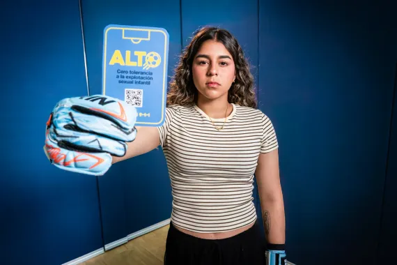 Futbolista sostiene la tarjeta azul de la campa&ntilde;a cero tolerancia contra la explotaci&oacute;n sexual