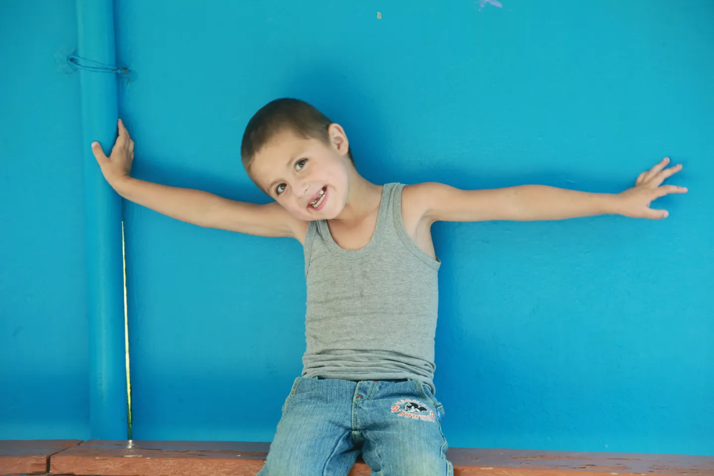 boy against a blue wall