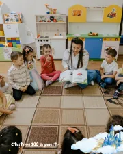 educatoare citește unui grup de copii