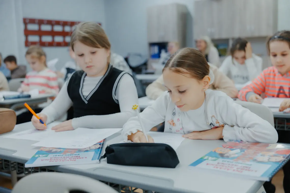 Refugee children learning romanian