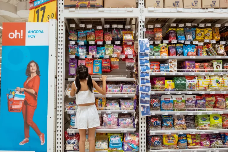 On 30 March 2023 in Lima, Peru, Micaella Delgado, 8, looks at packages of candy in a supermarket. She chooses the candies that are displayed at her height.