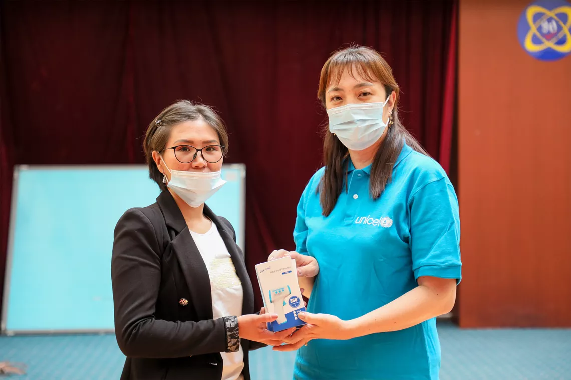 Handing over infrared thermometer.