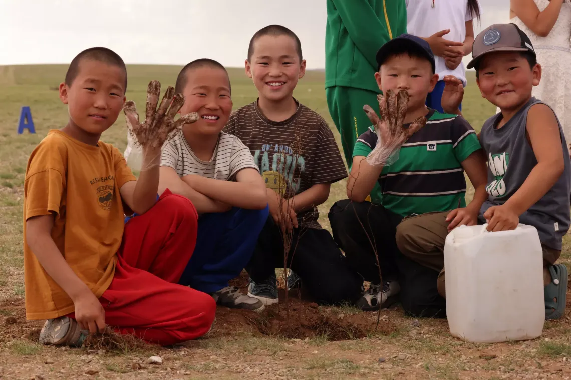 Children planting trees outside of their classroom