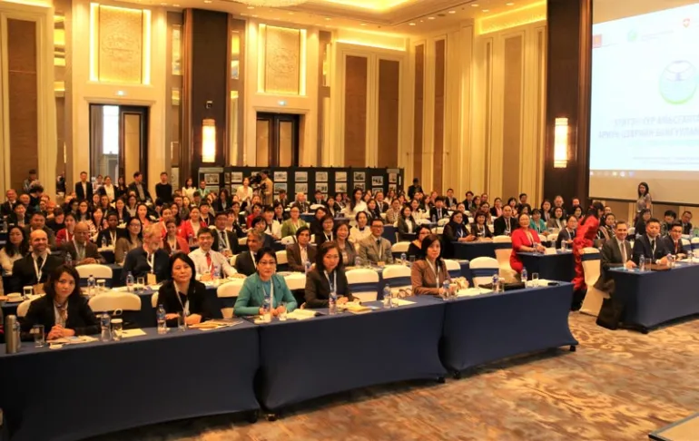 People sitting at rows of tables in a conference room