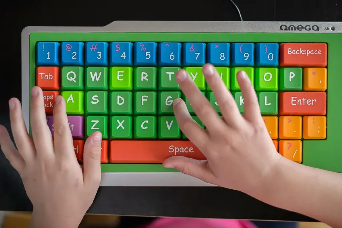 A child typing on a keyboard