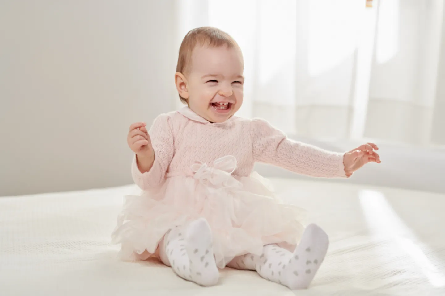 A baby girl sitting in a dress