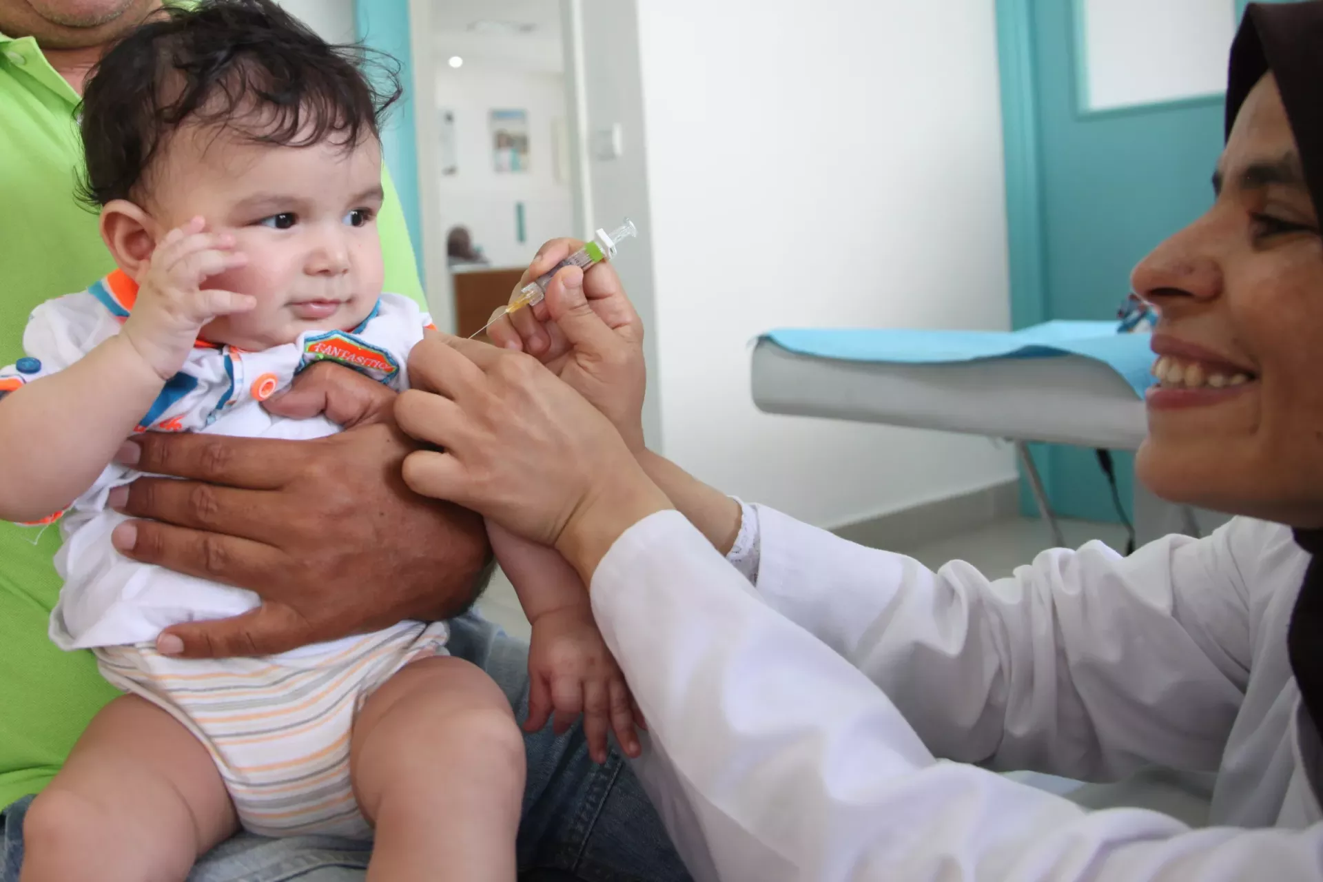 Un b&eacute;b&eacute; re&ccedil;oit un vaccin dans le bras par une infirmi&egrave;re souriante dans un centre m&eacute;dical.