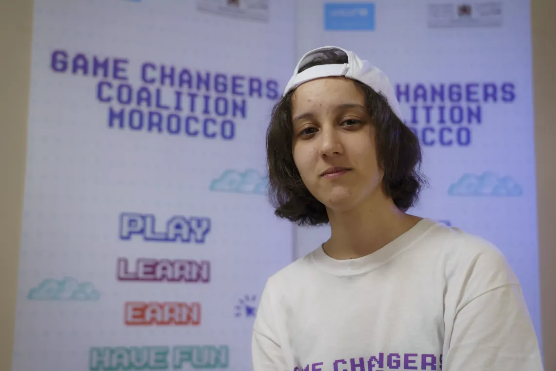 Une jeune fille portant une casquette pose devant la cam&eacute;ra.