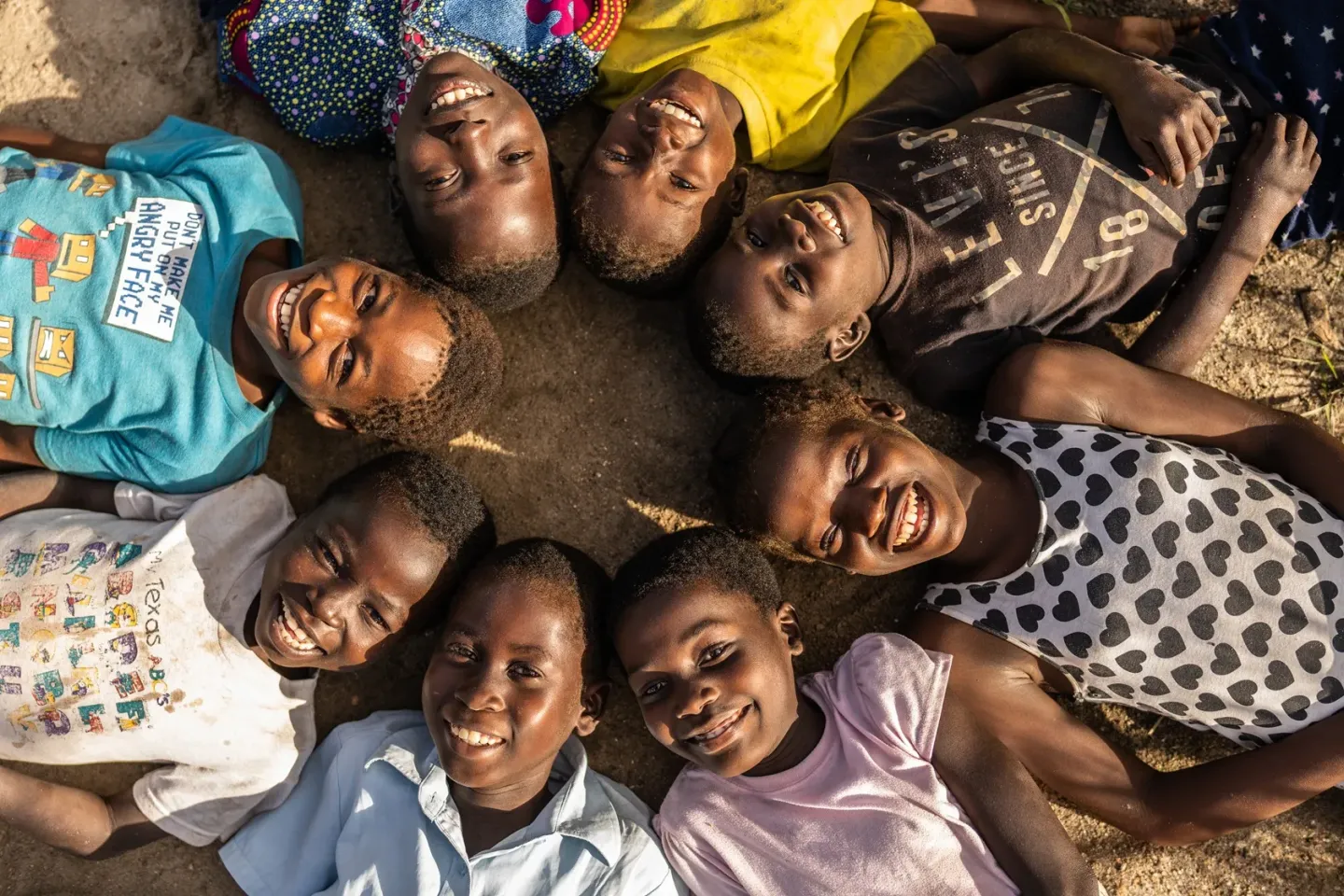 Group of children laying on the floor in a circle.
