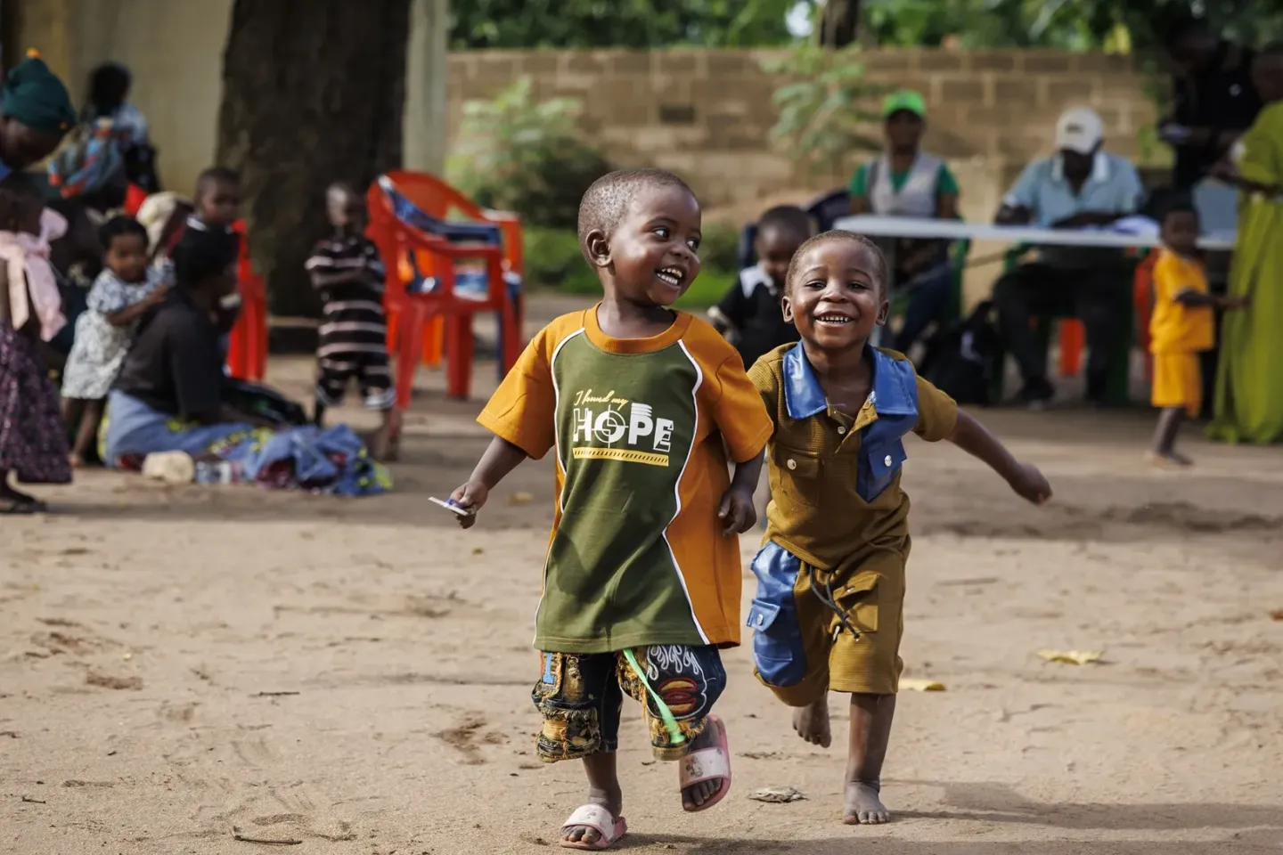 Two young boys smiling and running in an open field in Cabo Delgado, Mozambique.