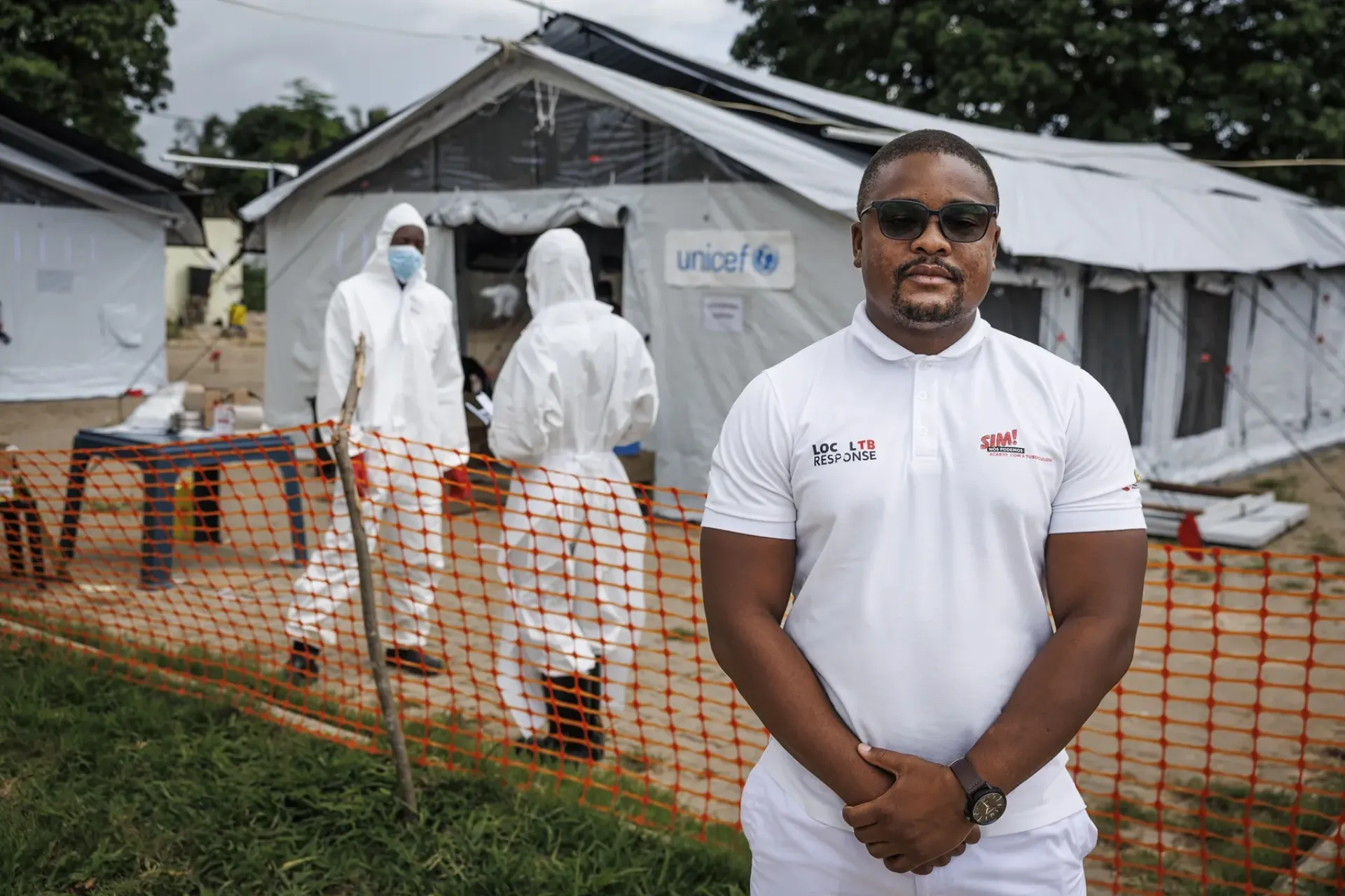 Dr Julfrique Bila, 32, Chief Medical Officer for Nacala District, stands in front of large white tents donated by UNICEF.