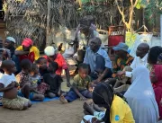 Men and children from Horta-C sit together during the community dialogue, part of the audience gathered after the performance.