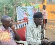 Two older men sit among the audience during the dialogue in Horta-C.