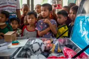 Children listen attentively during the unboxing of a recreation kit.
