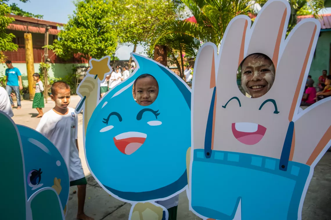 A group of children posting with the handwashing mascots. 