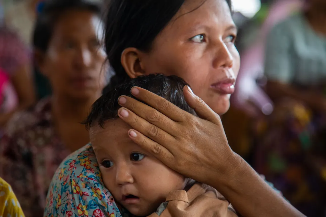 A mother holding her son close to her body. 