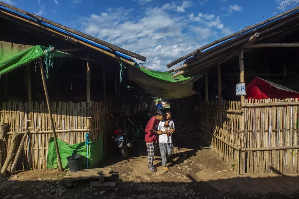 Two boys standing between temporary settlements in an IDP camp in Kachin State, Myanmar. 