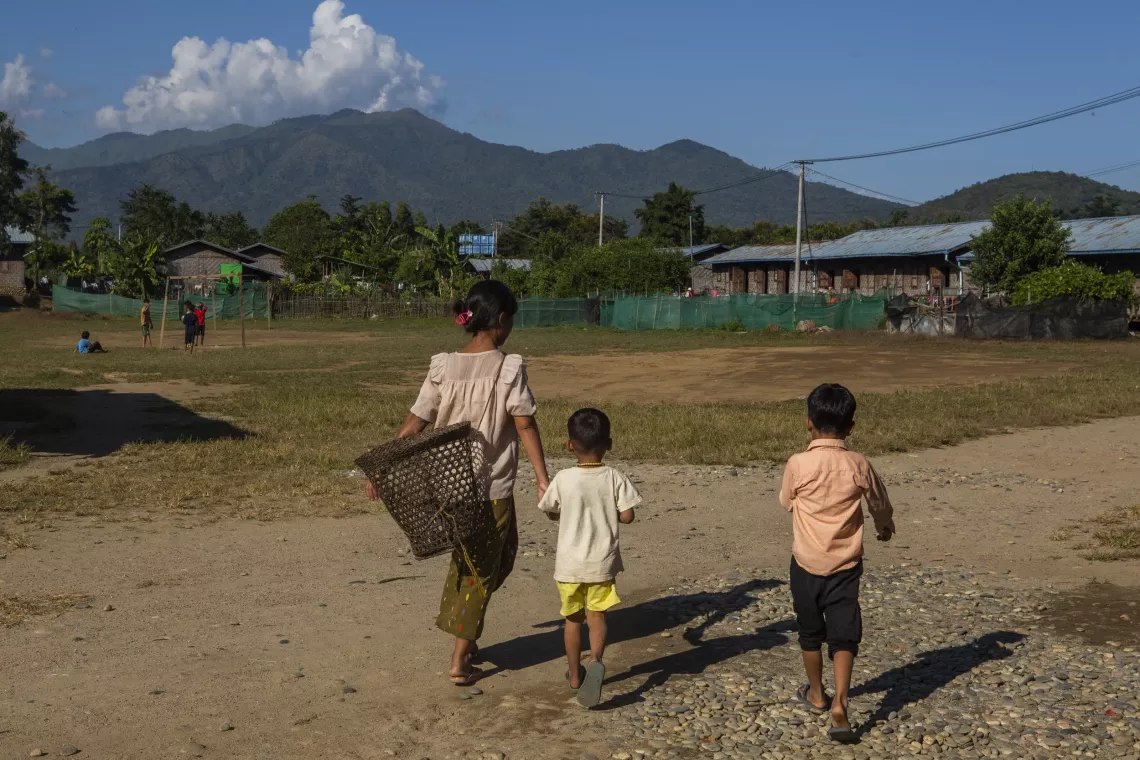 A group of children walking on a dirt path in an IDP camp in Kachin State, Myanmar